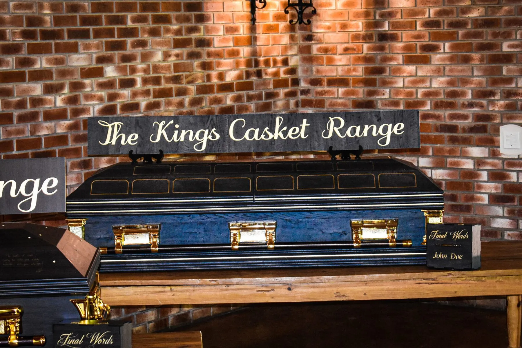 The Kings Casket Range in navy finish with gold pinstripe trim